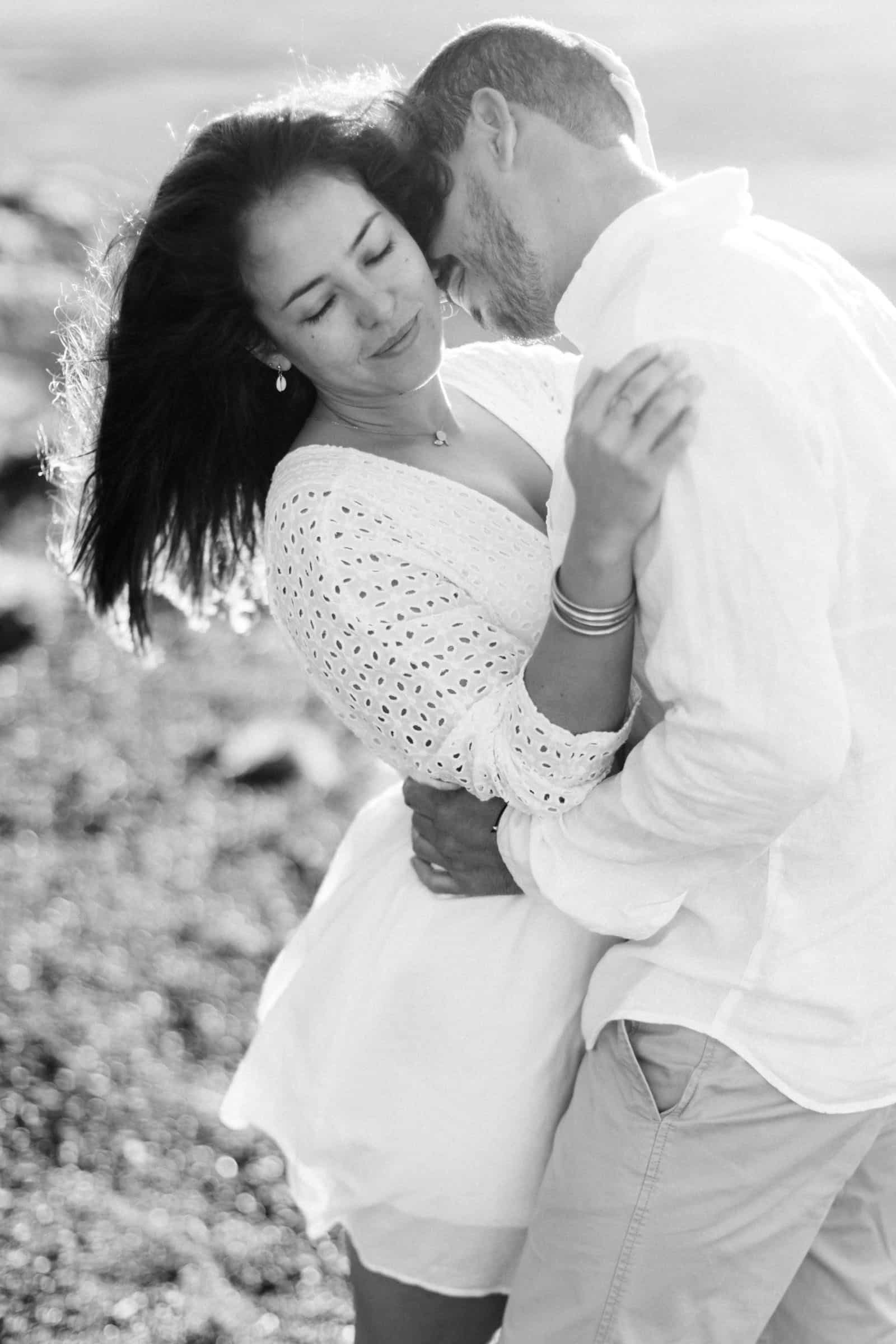 Photographie en noir et blanc de Mathieu Dété, photographe de mariage et famille à Saint-Benoît de la Réunion 974, présentant un couple enlacé au lever du soleil