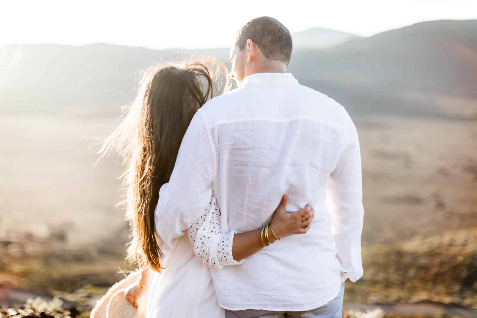 Photographie de Mathieu Dété, photographe de mariage et famille à Saint-Gilles sur l'île de la Réunion 974, présentant un couple enlacé par la taille au lever du soleil en contre-jour durant une séance couple