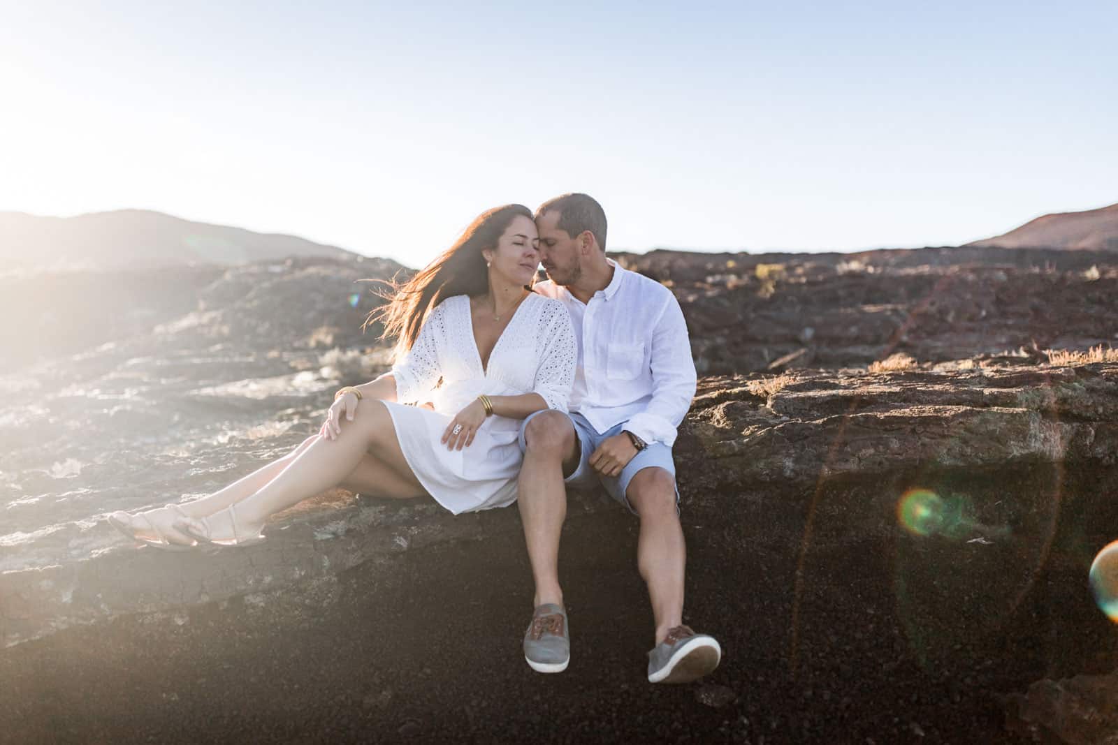 Photographie de Mathieu Dété, photographe de mariage et famille à Saint-Gilles sur l'île de la Réunion 974, présentant un couple assis côte à côte sur une roche de la Plaine des Sables