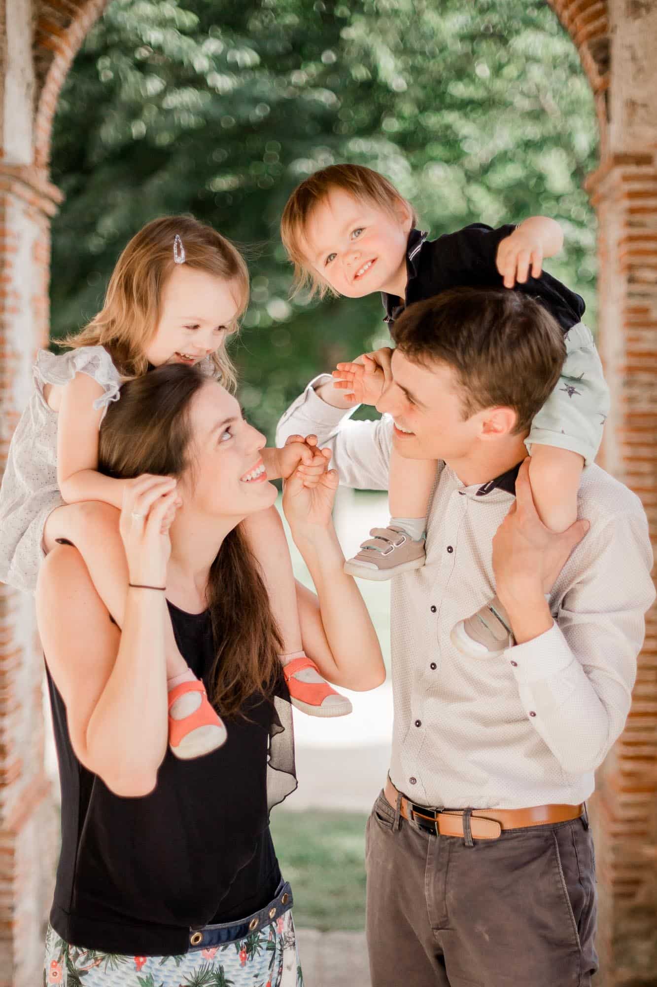 Photographie de Mathieu Dété, photographe de famille, de deux enfants sur les épaules de leurs parents