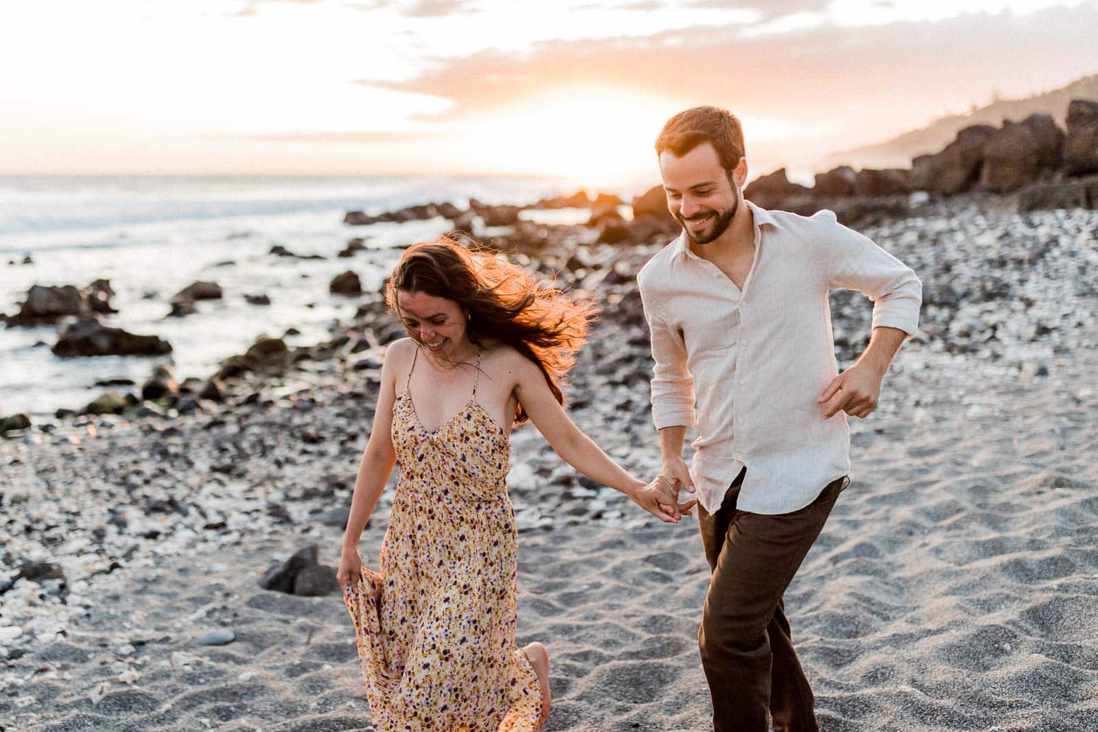 Photographie de Mathieu Dété, photographe de mariage et de couple à Saint-Joseph sur l'île de la Réunion 974, présentant un couple souriant courant sur la plage du Sud de la Réunion