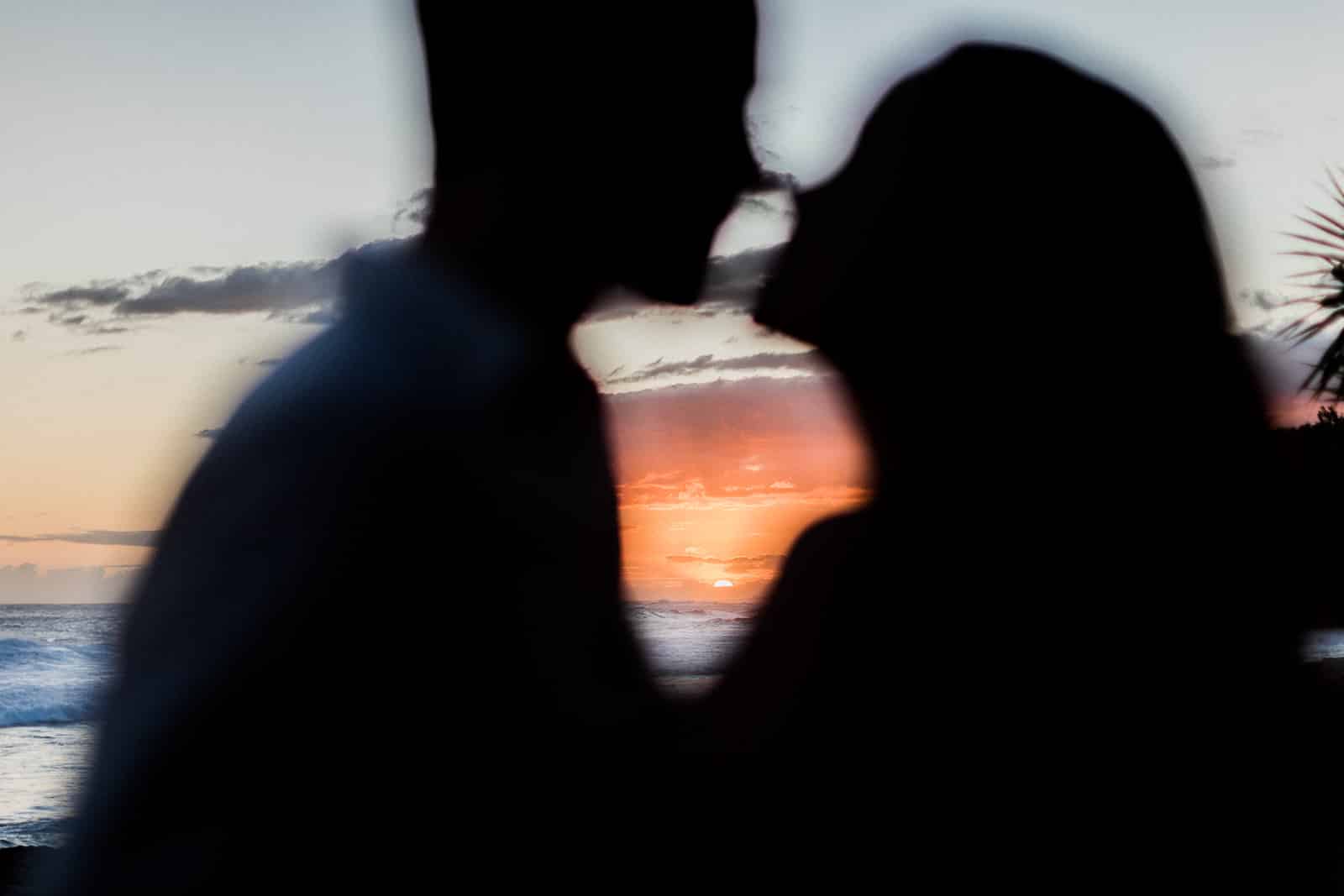 Photographie de Mathieu Dété, photographe de mariage et de couple à Saint-Joseph sur l'île de la Réunion 974, présentant le coucher de soleil à travers les silhouettes d'un couple