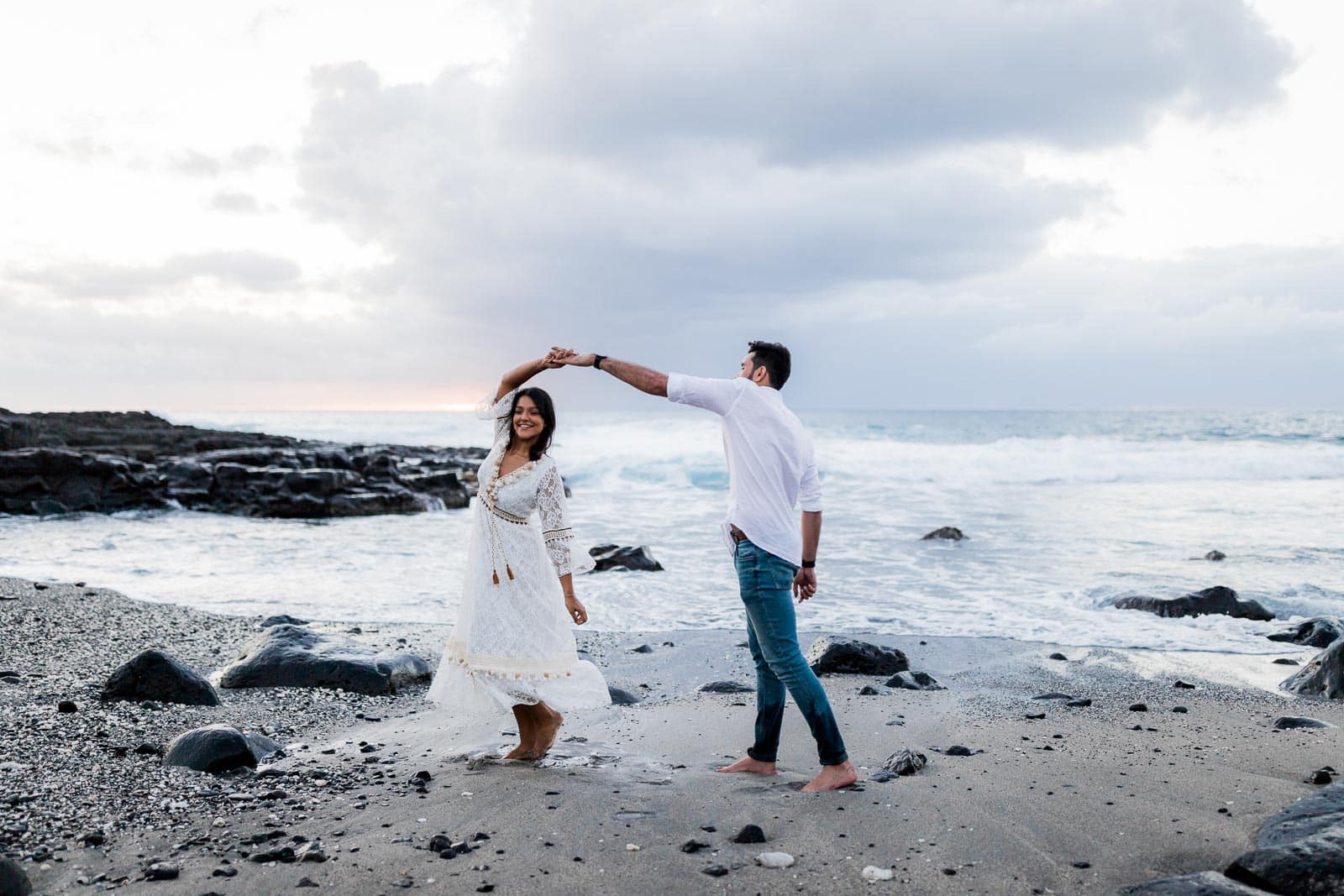 Photographie d'une séance photo au Cap La Houssaye, de Mathieu Dété, photographe de mariage et fiançailles à Saint-Pierre de la Réunion 974, présentant un couple qui danse en bord de mer au Cap la Houssaye