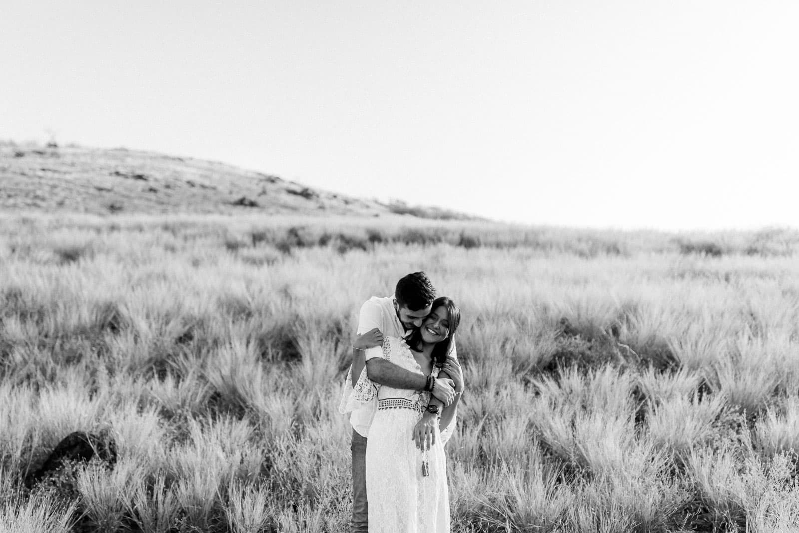 Photo d'une séance photo au Cap La Houssaye, de Mathieu Dété, en noir et blanc, photographe de mariage et famille à Saint-Gilles de la Réunion 974, présentant un couple enlacé dans la savane du Cap La Houssaye, près de Saint-Paul