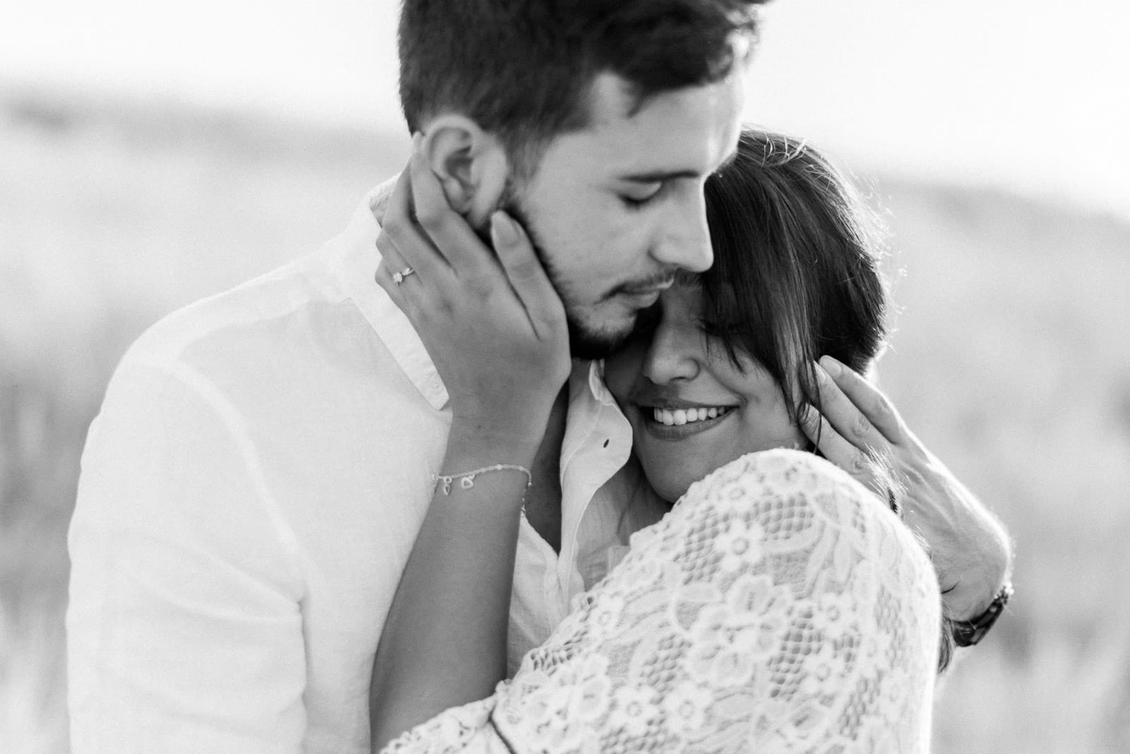 Photographie de Mathieu Dété en noir et blanc, photographe de mariage et famille à Saint-Gilles de la Réunion 974, présentant un couple enlacé dans la savane du Cap La Houssaye, près de Saint-Paul