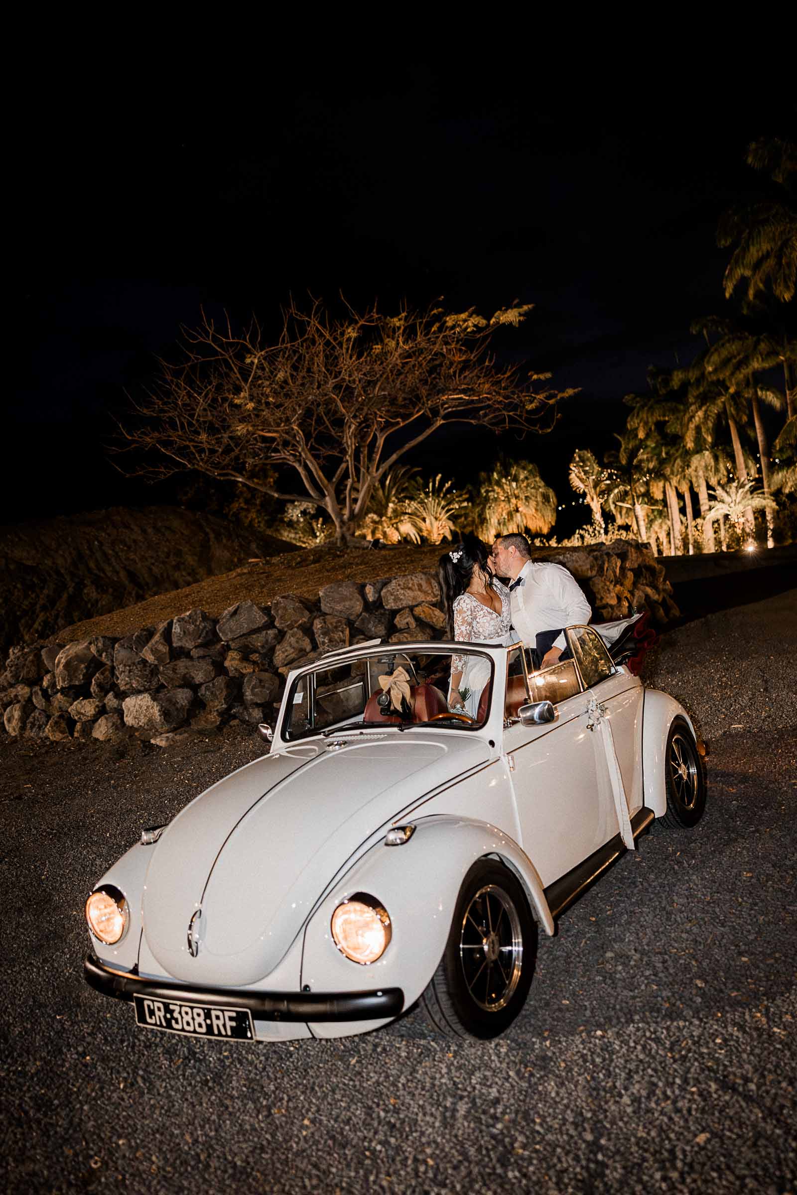Photographie de Mathieu Dété, photographe de mariage sur l'île de la Réunion 974, présentant les mariés s'embrassant dans leur voiture au Domaine des Palmiers à Saint-Paul