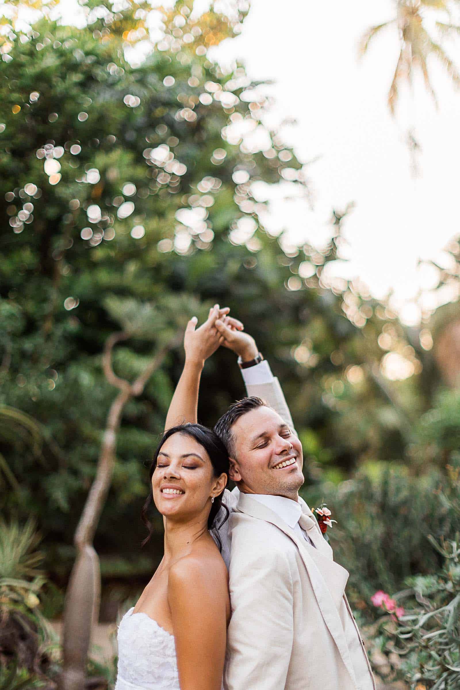 Photographie de Mathieu Dété, photographe de mariage et famille à Saint-Pierre sur l'île de la Réunion 974, présentant les mariés dos à dos devant les cactus du Jardin d'Eden de Saint-Gilles