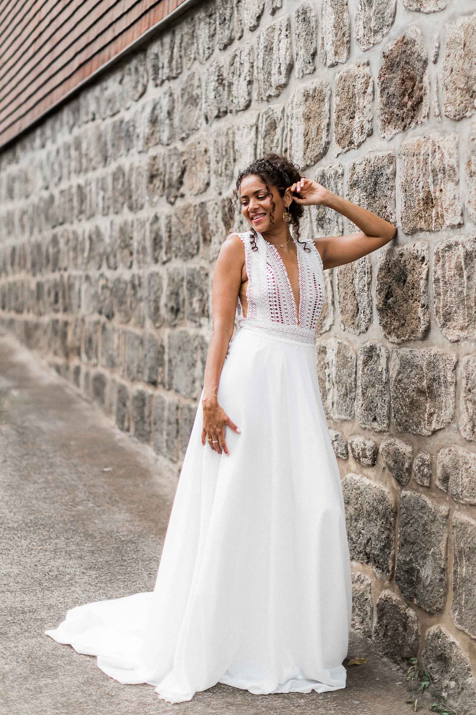 Photographie de Mathieu Dété, photographe de mariage et famille à Saint-Pierre sur l'île de la Réunion 974, présentant une modèle dans une robe de mariée devant un mur du Jardin Botanique Mascarin de Saint-Leu