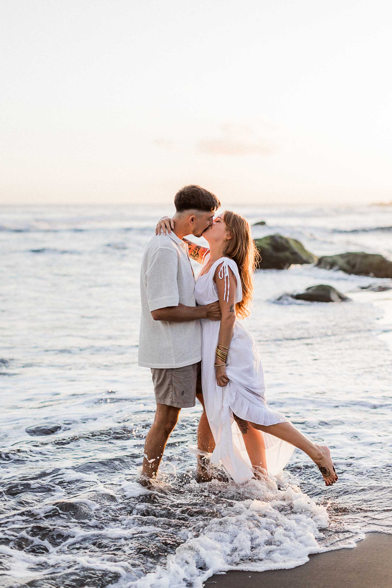 Photographie de Mathieu Dété, photographe de mariage sur l'île de la Réunion 974, présentant un couple s'embrassant les pieds dans l'eau sur la plage de la Ravine des Sables, à Etang Salé