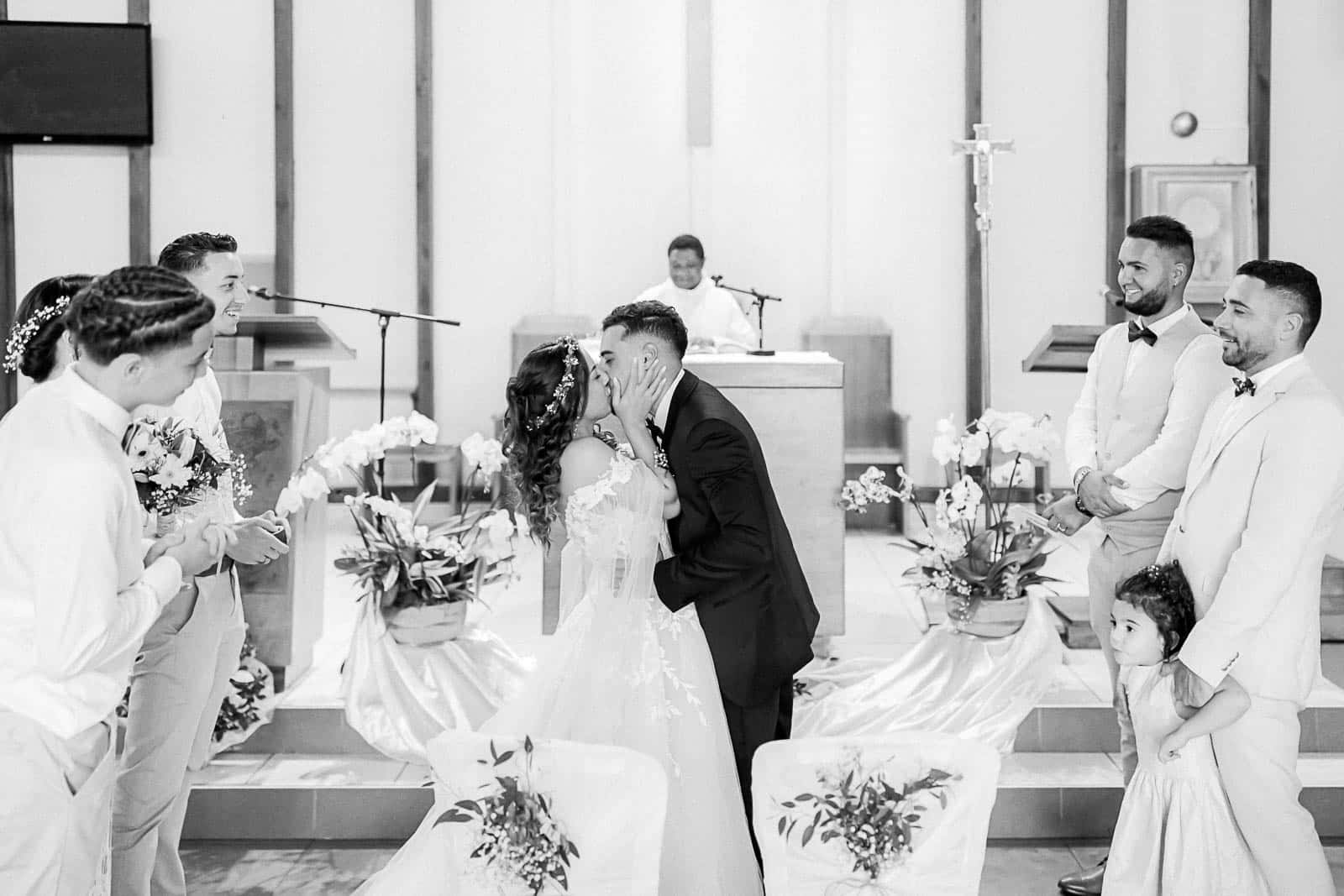 Photographie de Mathieu Dété, photographe de mariage et famille à Saint-Pierre sur l'île de la Réunion 974, présentant les mariés s'embrassant devant l'autel lors de la cérémonie religieuse