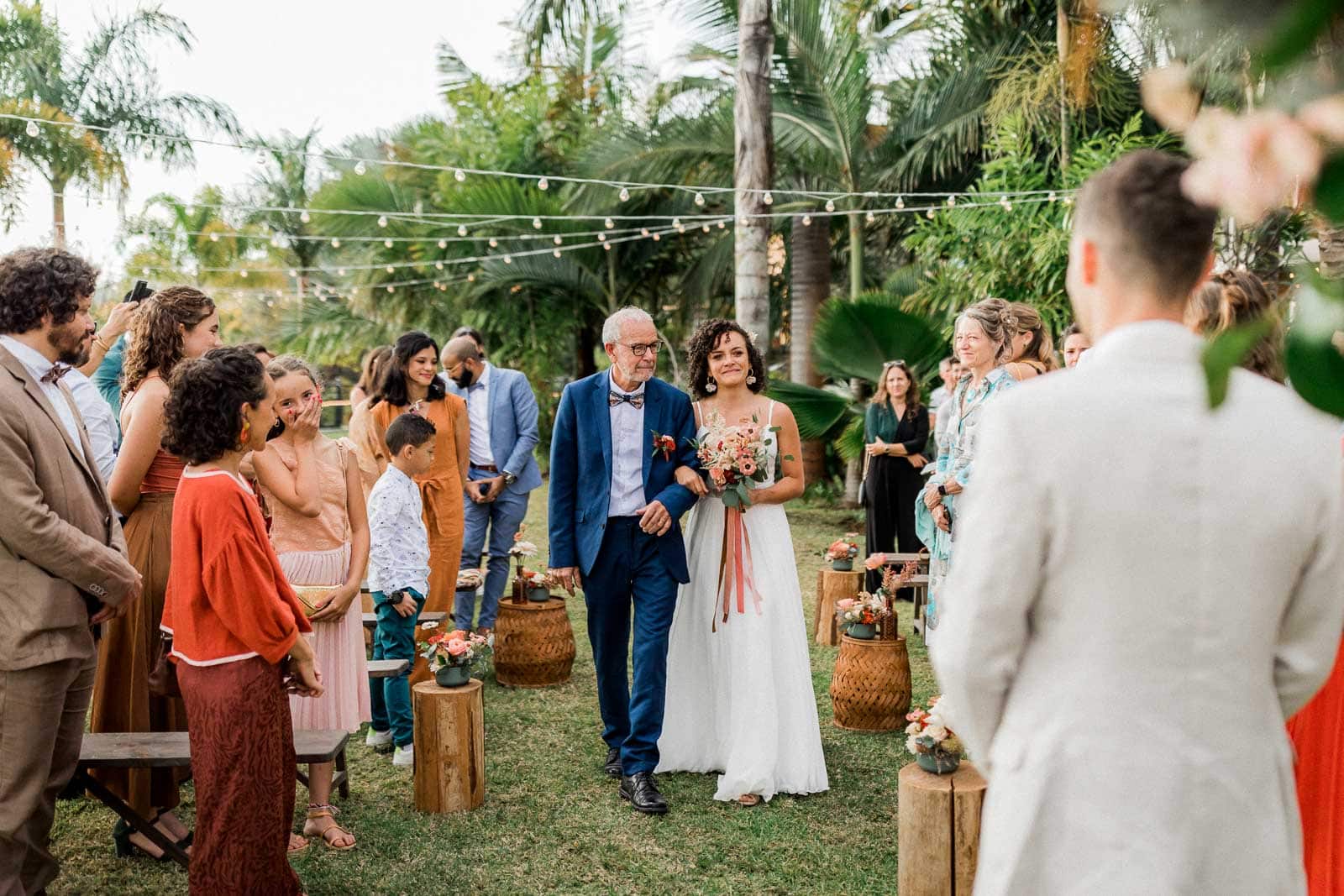 Photographie de Mathieu Dété, photographe de mariage et grossesse à Sainte-Marie, sur l'île de la Réunion 974, présentant l'entrée de la mariée dans la cérémonie laïque, aux bras de son papa