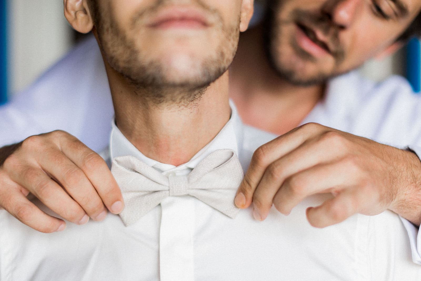 Photographie de Mathieu Dété, photographe de mariage et grossesse à Saint-Paul, sur l'île de la Réunion 974, présentant les détails du noeud papillon du marié, accroché par son témoin