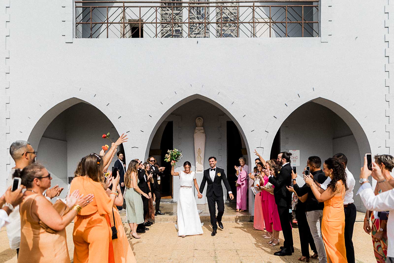 Photographie de Mathieu Dété, photographe de mariage à Saint-Leu sur l'île de la Réunion 974, présentant la sortie de la cérémonie religieuse devant l'église de Saint-Gilles-les-Bains