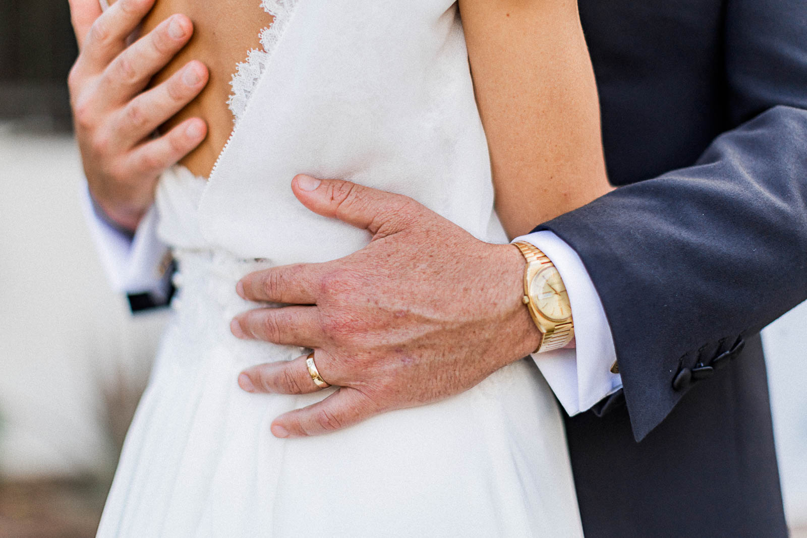 Photographie de Mathieu Dété, photographe de mariage à Saint-Leu sur l'île de la Réunion 974, présentant les détails des mains du marié avec son alliance, enlaçant la taille de la mariée