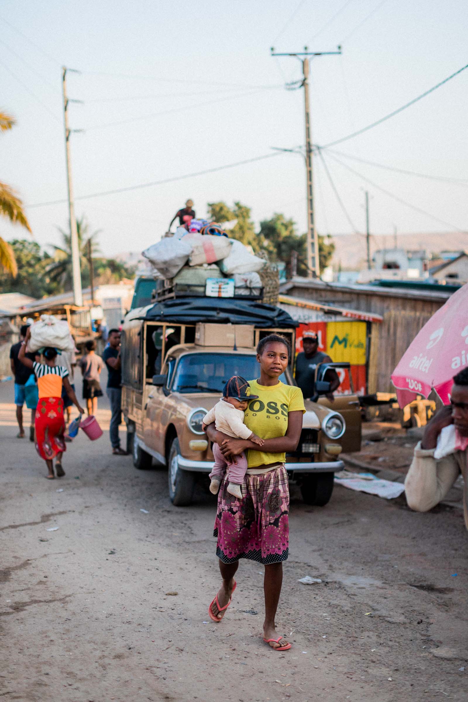 Photographie de Mathieu Dété, photographe de mariage et de voyage à la Réunion 974, présentant une photo d'un voyage à Madagascar, avec une femme et son fils marchant dans la rue au lever du jour