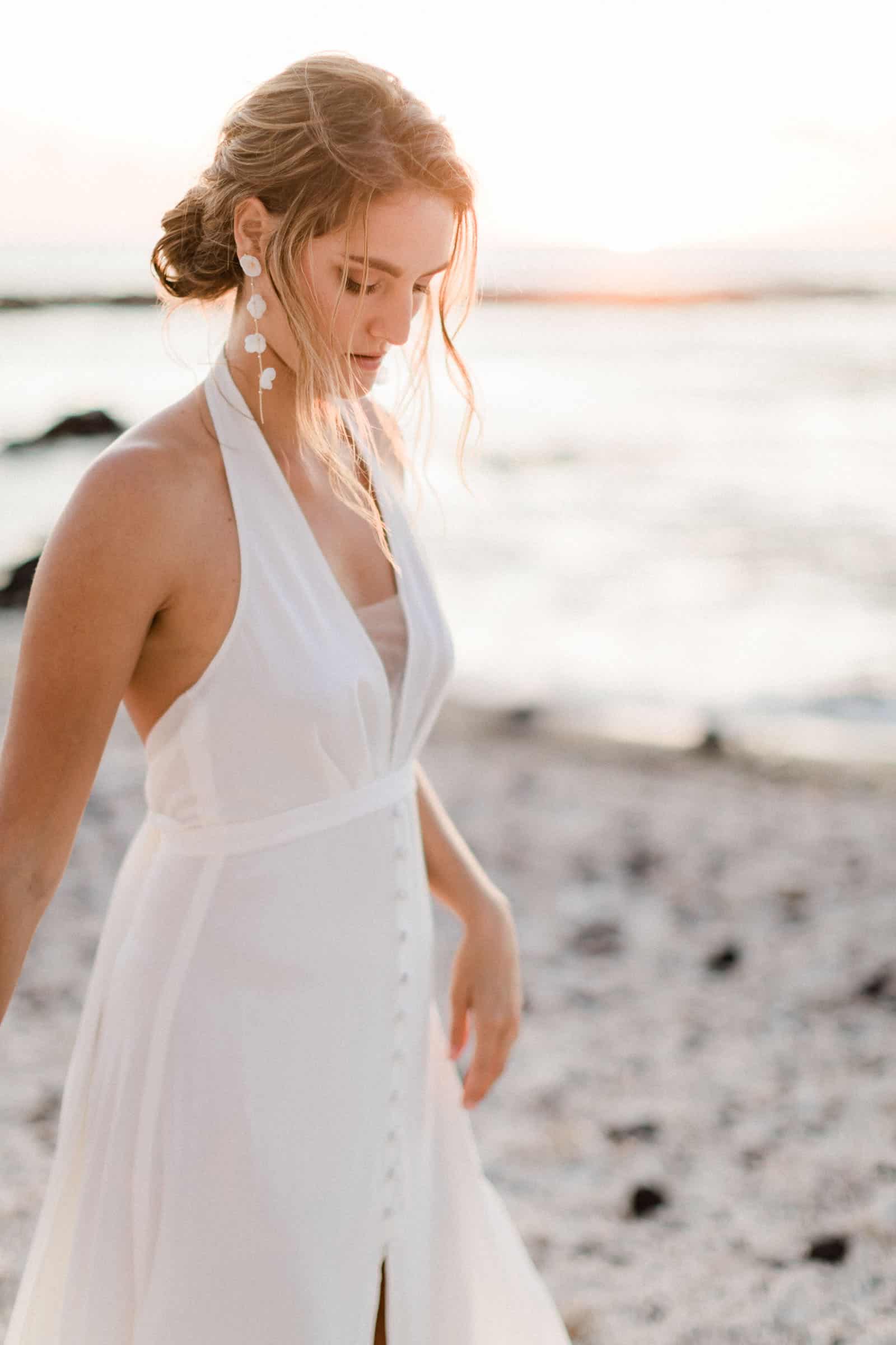 Photographie de Mathieu Dété, photographe de mariage, de mode et de couple à Saint-Leu sur l'île de la Réunion 974, présentant Emma, en robe de mariée de la marque Maison Mananne, marchant dans les coraux de la crique de la Pointe au Sel