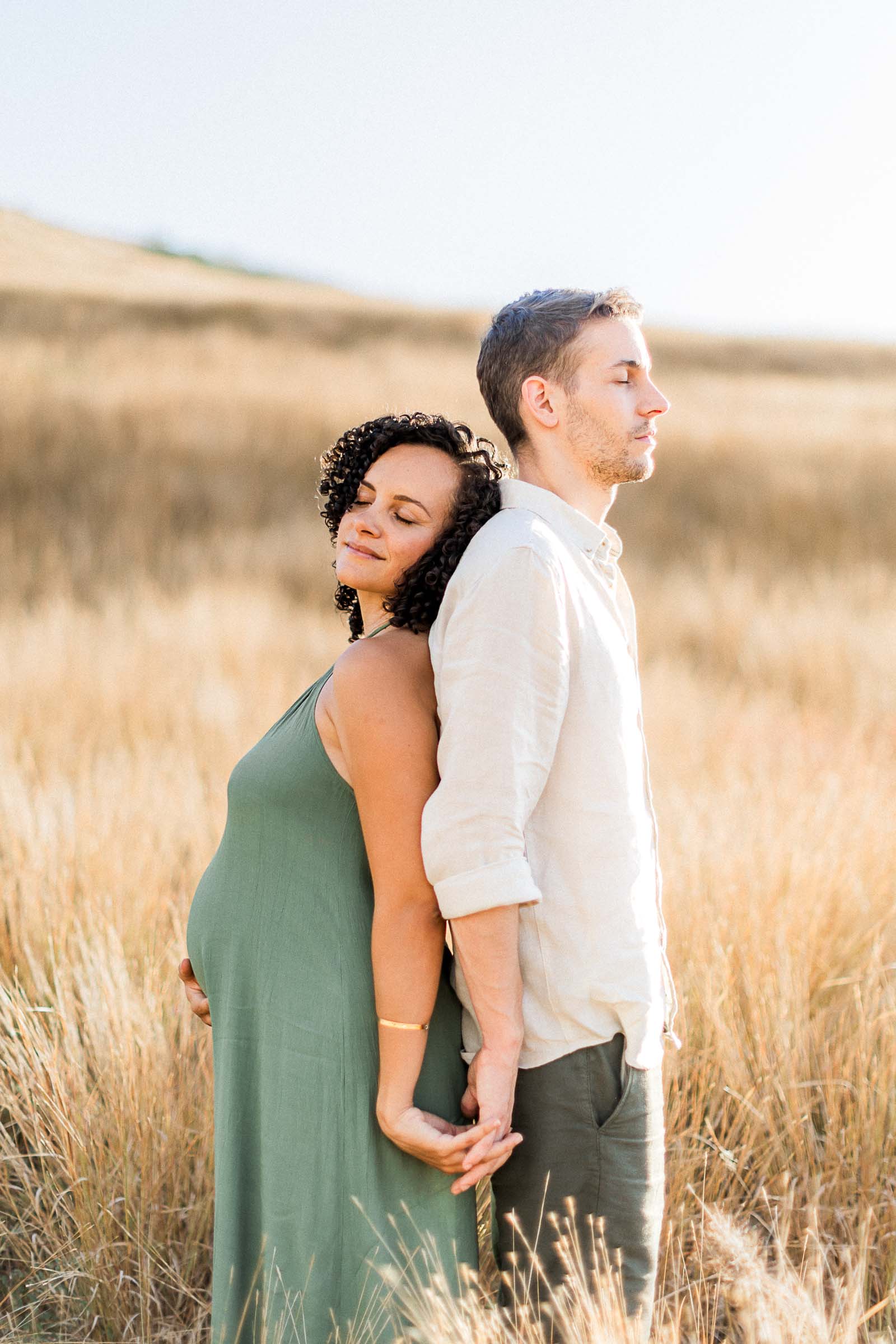 Photographie de Mathieu Dété, photographe de mariage à Saint-Pierre de la Réunion 974, présentant un couple dos à dos dans la savane de Saint-Paul, lors d'un shooting grossesse