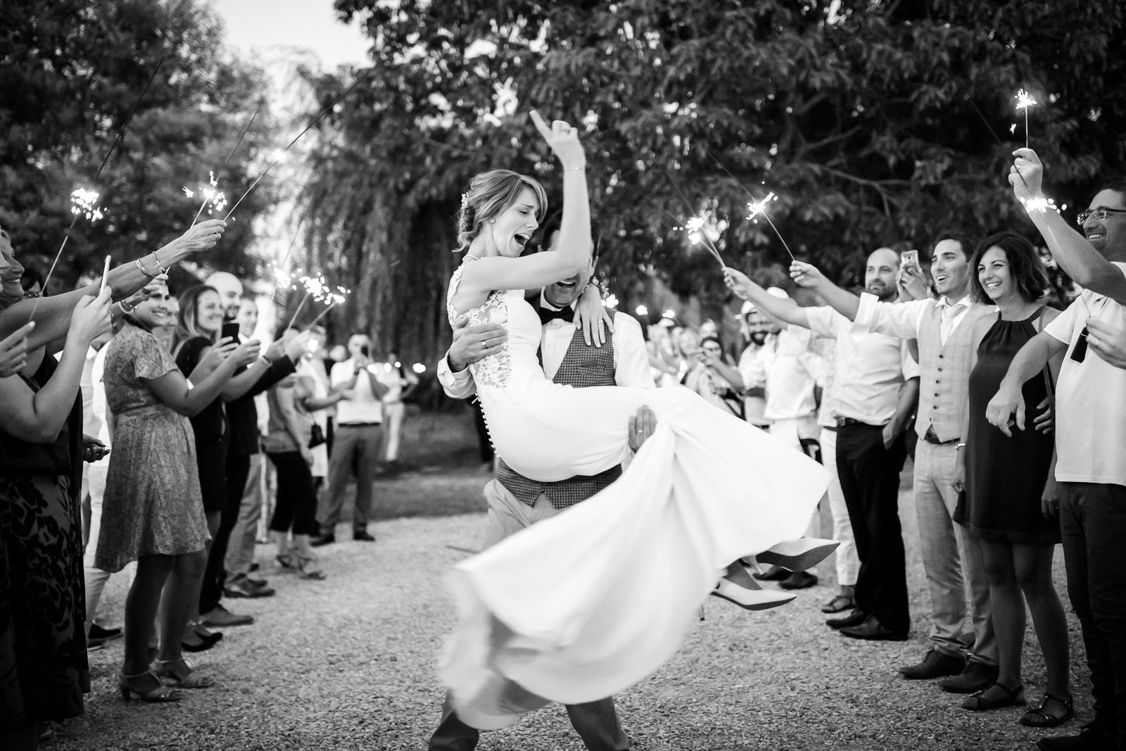 Photo de Mathieu Dété, photographe de mariage, lors d'un mariage sur l'île de la Réunion 974, à Saint-Paul, représentant une mariée heureuse avec ses invités, en noir et blanc