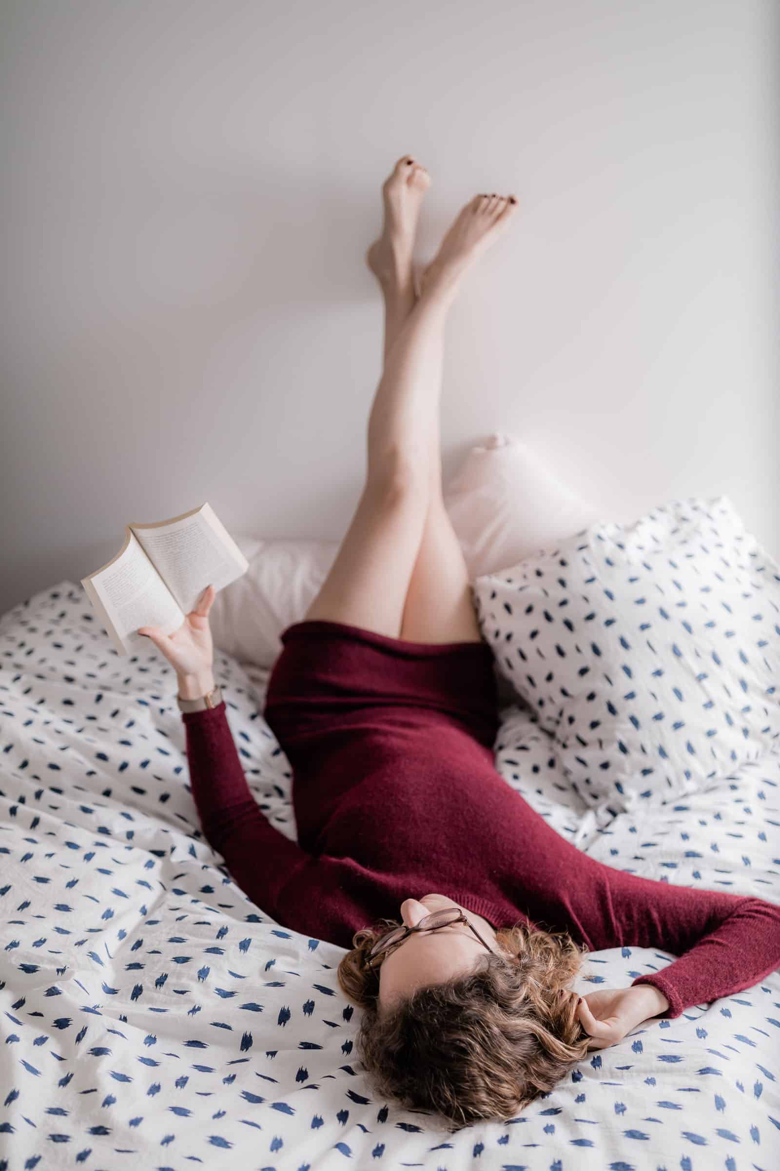 Femme couchée qui lit sur le lit